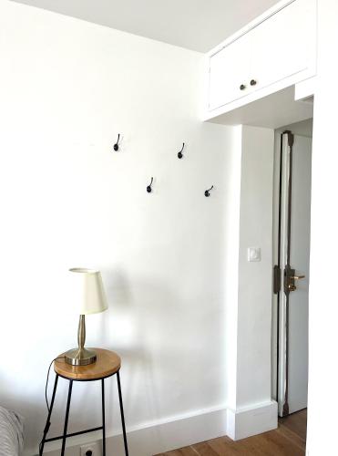une chambre avec une table et une lampe sur un mur dans l'établissement Eiffel Tower - Cosy Studio, à Paris