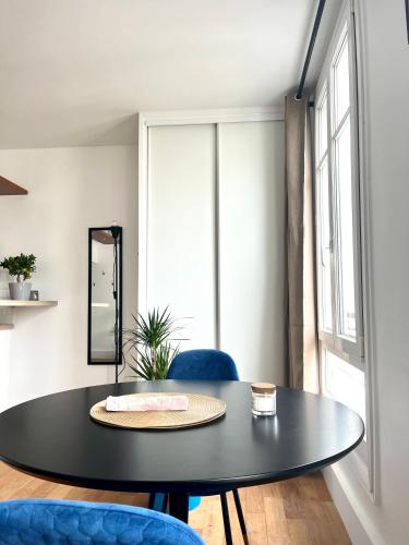 - une salle à manger avec une table et deux chaises bleues dans l'établissement Eiffel Tower - Cosy Studio, à Paris