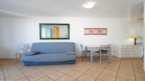 un salon avec un canapé bleu et une table dans l'établissement La Lamparo n202 - 2P4, au Cap d'Agde