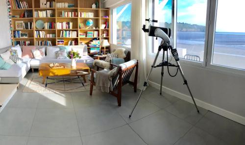 - une caméra dans le salon doté d'une télévision et d'un canapé dans l'établissement Maison pieds dans l'eau d'exception en Bretagne !, à Plérin