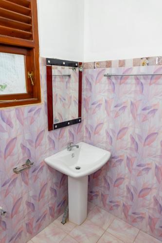a bathroom with a sink and a mirror at Nandana Guest House in Watagedaramulla
