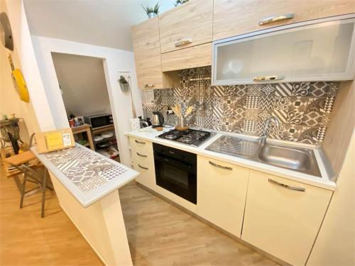 a kitchen with a sink and a stove top oven at Casa Anacleto in Iglesias