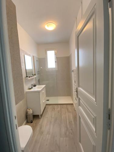 une salle de bain avec des toilettes, un lavabo et une porte dans l'établissement Duplex cosy très proche de La Défense, à Nanterre