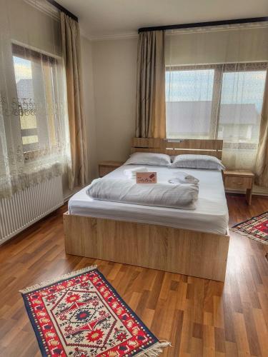 a bedroom with a bed and two rugs on the floor at Casa Vădeanu in Sighetu Marmaţiei