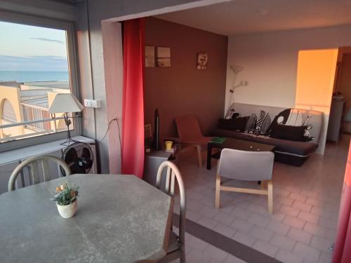 une chambre avec une table et un salon avec vue dans l'établissement Brise de mer, à Frontignan