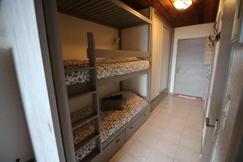 une chambre avec trois lits superposés dans une pièce dans l'établissement Praloup 1600 joli studio vue panoramique, à Pra-Loup