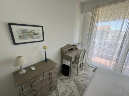- une chambre avec une commode et un bureau à côté d'une fenêtre dans l'établissement Cozy one bedroom apartment with balcony and parking, à Cannes