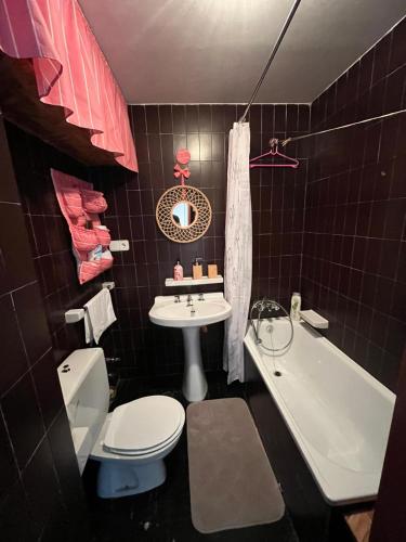 a bathroom with a toilet and a sink and a tub at Dupléx en Estación de Manzaneda in Prada