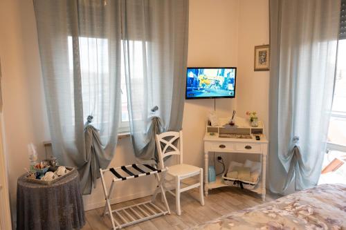 a bedroom with a bed and a desk and a television at La Garampa in Cesena
