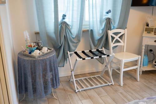 a room with two chairs and a window with blue curtains at La Garampa in Cesena