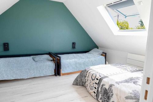 - une chambre mansardée avec 2 lits et une fenêtre dans l'établissement Villa Gozforn - Piscine et plage à pied, à Fouesnant