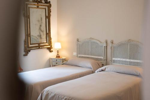 two beds in a room with a mirror on the wall at La Garampa in Cesena