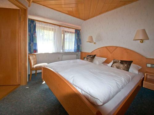 a bedroom with a large bed and a window at Gästehaus Herrmann in Wolf