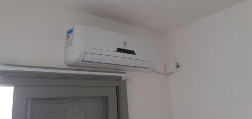 a white air conditioner on the ceiling of a door at Apartamento 01 quarto superior in Torres