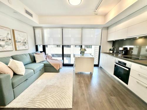 a living room with a blue couch and a kitchen at Condo in Yorkville - Newly Furnished Luxury Unit in Toronto