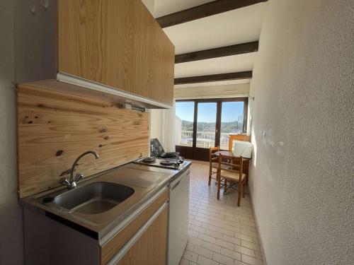 une cuisine avec un évier et un plan de travail dans l'établissement Studio Port Soleil PS604 - 2 personnes accès Piscine, au Cap d'Agde