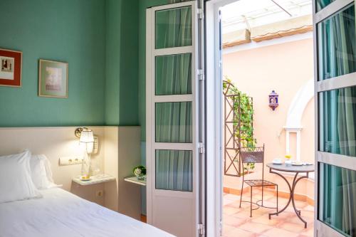 a bedroom with a bed and a door leading to a patio at Hotel Veracruz in Utrera
