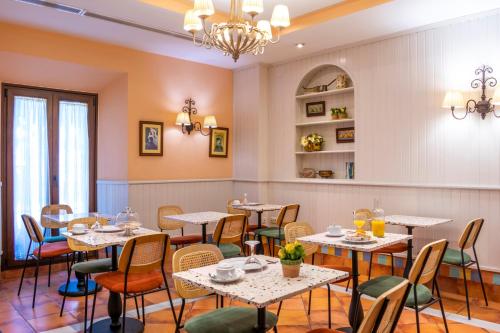a restaurant with tables and chairs and a chandelier at Hotel Veracruz in Utrera