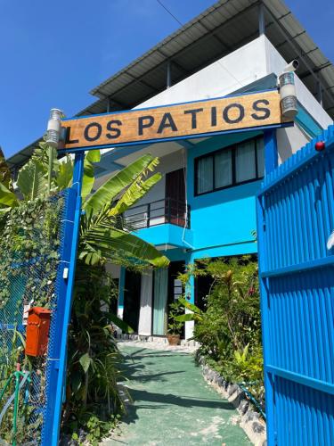 a blue house with a sign that reads los patios at Los Patios Hostel Phuket in Mai Khao Beach