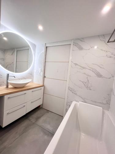 une salle de bain avec une baignoire, un lavabo et un miroir dans l'établissement Maison Avignon intra-muros, à Avignon