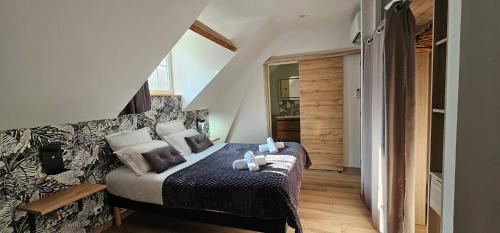 a bedroom with a bed with pillows on it at Le Clos Maldier - Gîte de la Belle vue in Laon