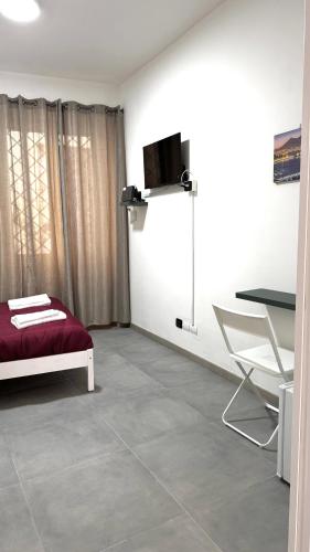 Camera con letto, tavolo e sedia di House Piazza Plebiscito by Loveinthetravel a Napoli