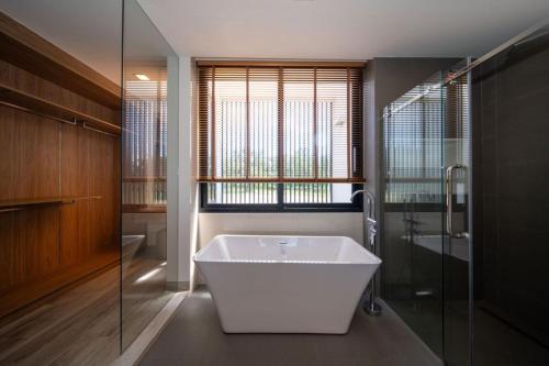 a bathroom with a tub and a glass shower at Private pool villa bangtao - laguna park in Ban Phru Champa