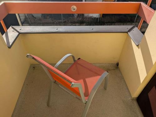 a red chair sitting in a small room at Stadthotel Augsburg in Augsburg