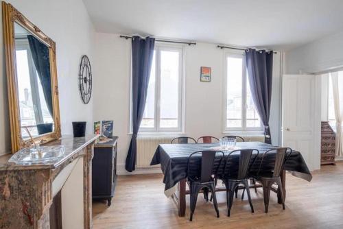 une salle à manger avec une table et des chaises noires dans l'établissement Le Boujou - Place de parking - 200m plage, à Étretat