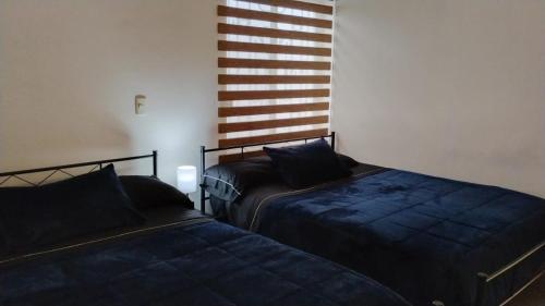 two beds sitting next to each other in a room at Cumbresuites in Monterrey