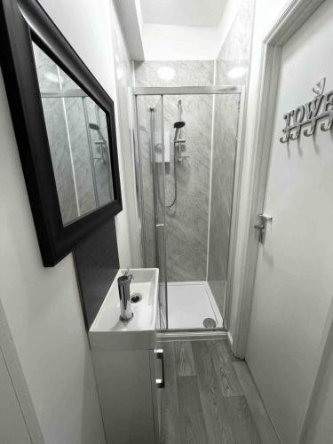 a bathroom with a shower and a sink at BH2 Beach House in Bournemouth