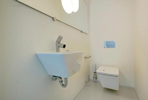 une salle de bain blanche avec un lavabo et des toilettes dans l'établissement 2 chambres WC séparés, à Saint-Germain-du-Crioult