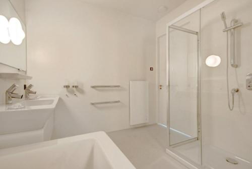 une salle de bain blanche avec une douche et un lavabo dans l'établissement 2 chambres WC séparés, à Saint-Germain-du-Crioult