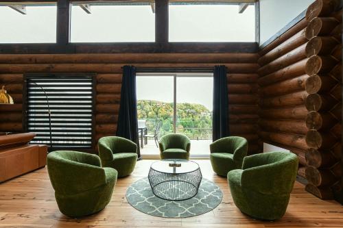 un soggiorno con sedie verdi e tavolo di Sommet White Golf Hot tub Ski 10min a Saint-Faustin