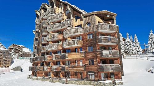 a large wooden building in the snow at DEUX PIÈCES CHALEUREUX VUE IMPRENABLE Résidence Datcha AU PIED DES PISTES in Avoriaz