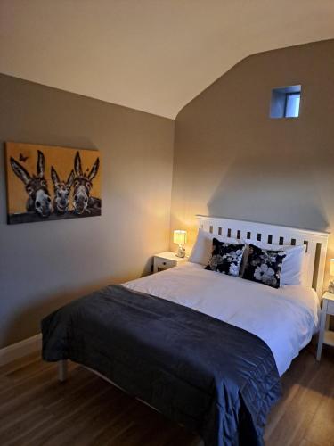 a bedroom with a bed with two deer heads on the wall at Rose Meadow Lodge in Liscannor