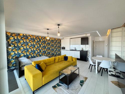 un soggiorno con divano giallo e una cucina di Apartament Voir a Rzeszów
