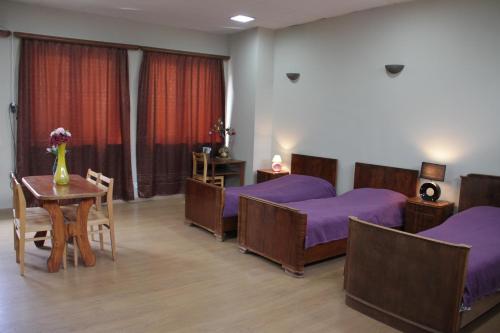 1 dormitorio con 2 camas, mesa y sillas en Sololaki 7 Guest House, en Tiflis
