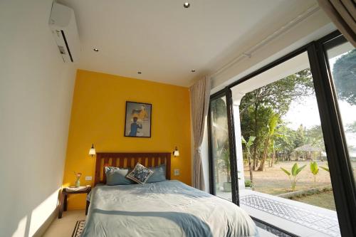 a bedroom with a bed and a large window at Charm Vân Long in Ninh Binh