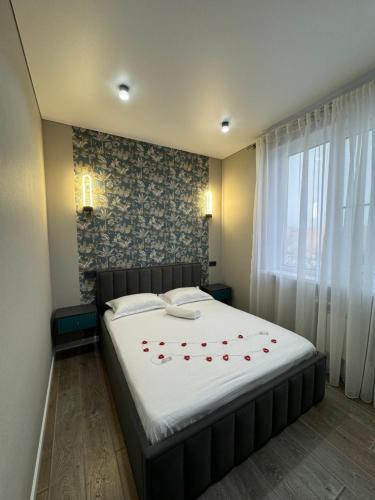 a bedroom with a bed with red roses on it at Gold Apple apartments in Oral