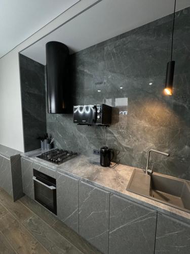 a kitchen with a sink and a stove at Gold Apple apartments in Oral