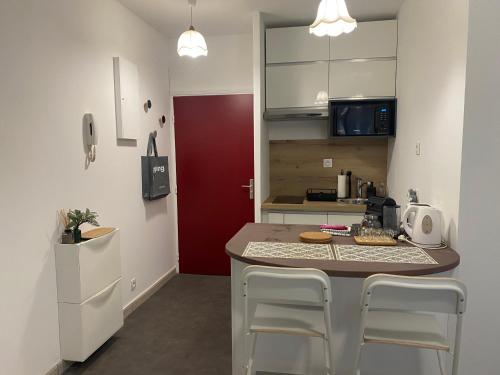 une cuisine avec un comptoir avec des chaises et un îlot de cuisine dans l'établissement Annecy centre, charmant studio, à Annecy