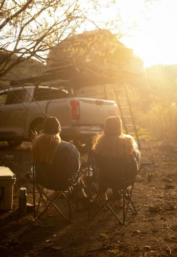 two people sitting in lawn chairs in the sunlight at Camper camioneta equipada cajon del maipo in San José de Maipo