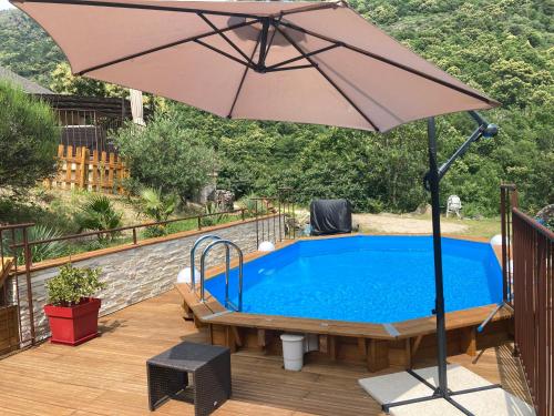 - un parasol sur une terrasse à côté de la piscine dans l'établissement Villa en pleine nature avec piscine, à Sablières