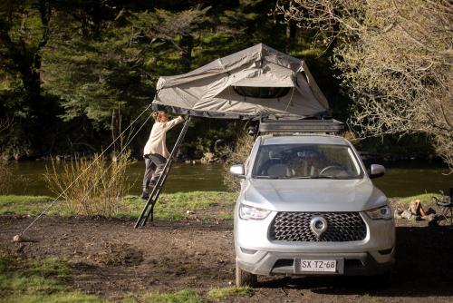 a man with a tent on top of a car at Camper camioneta equipada cajon del maipo in San José de Maipo