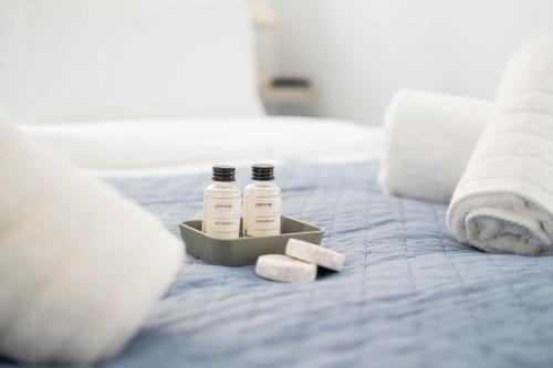 two bottles of medicine sitting on a bed at Santa Rosa Apartments in Kalamata