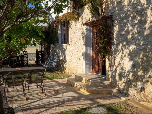 a stone building with a door and a table and chairs at Beautiful house with garden and amazing lake view in Kastoria