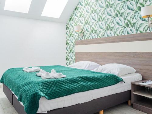 a bedroom with a bed with a green blanket at Bormio 27 Czarna Góra in Sienna