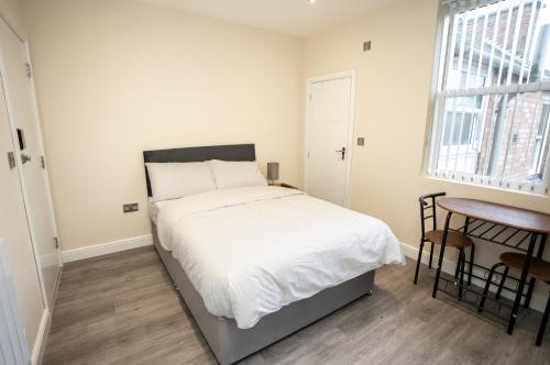 a bedroom with a bed and a table and a window at Park View in Leicester