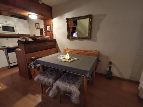 une salle à manger avec une table, des chaises et un miroir dans l'établissement Duplex Chalet Edelweiss - La Plagne Montalbert, à Montalbert